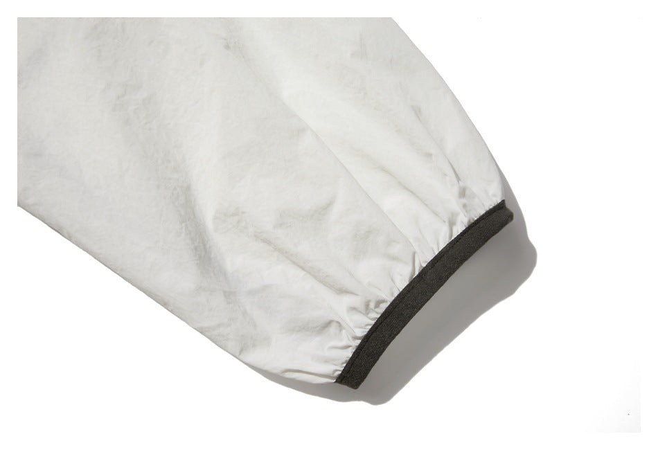 Close-up of an off-white sleeve ending in a dark charcoal cuff band.
