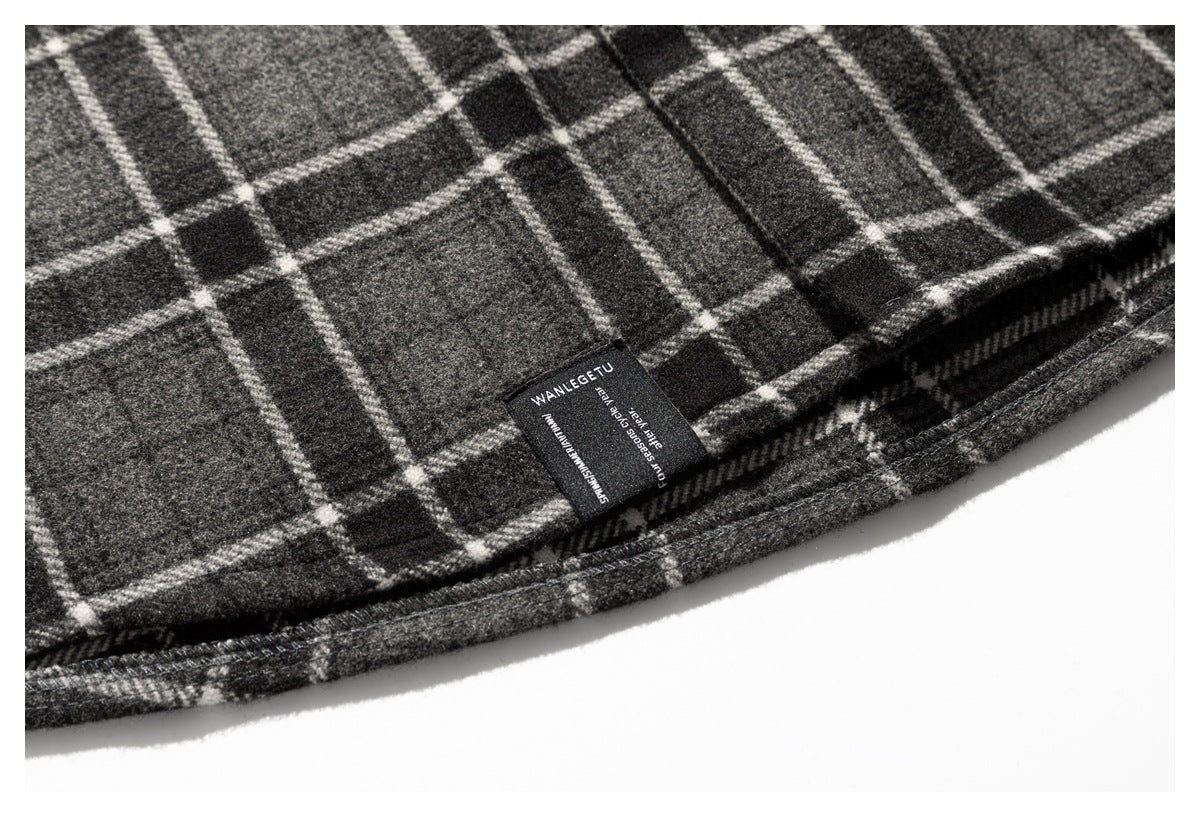 Close-up of the plaid garment hem and a sewn-in black label with English text.
