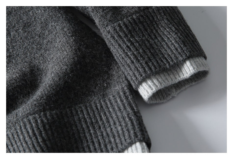 Close-up of the sweater's charcoal ribbed cuff with a light gray contrast edge.