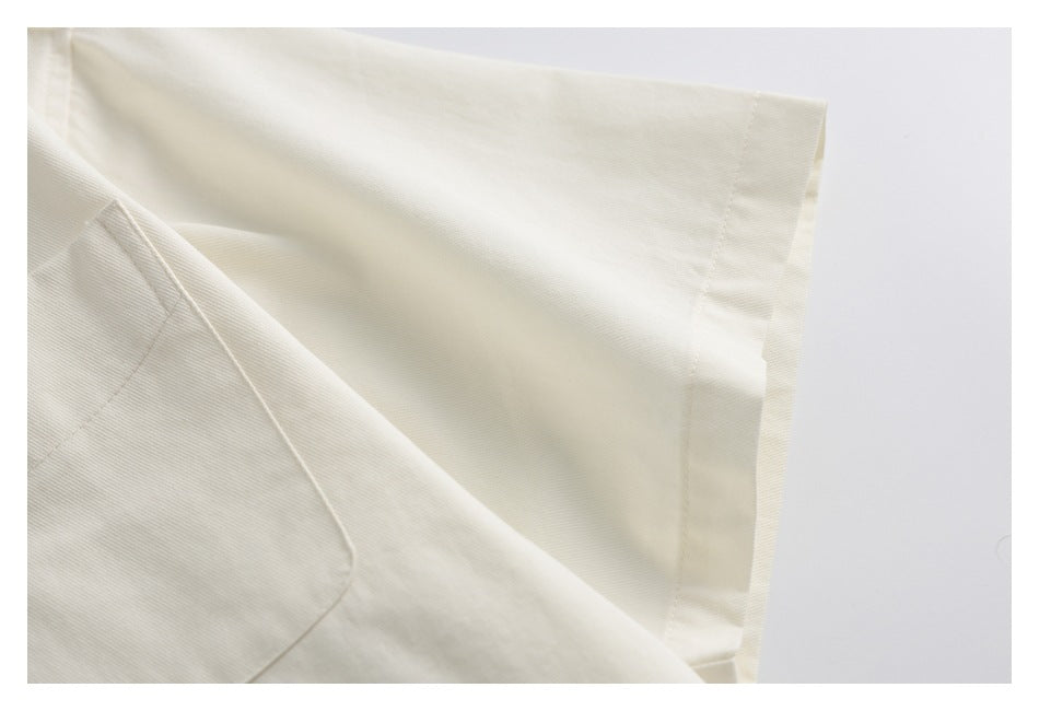 Close-up of an ivory garment's folded sleeve cuff and stitching.
