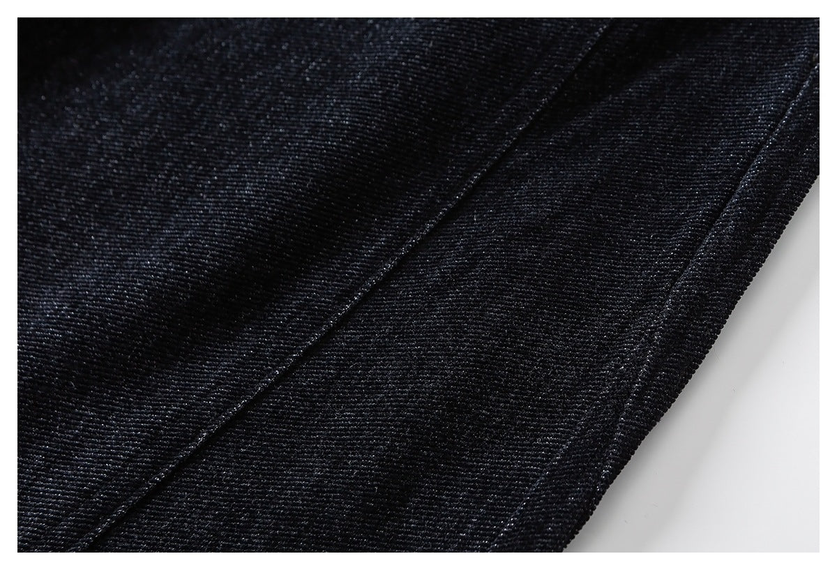 Close-up of black pants fabric with a diagonal stitched seam and finished edge.