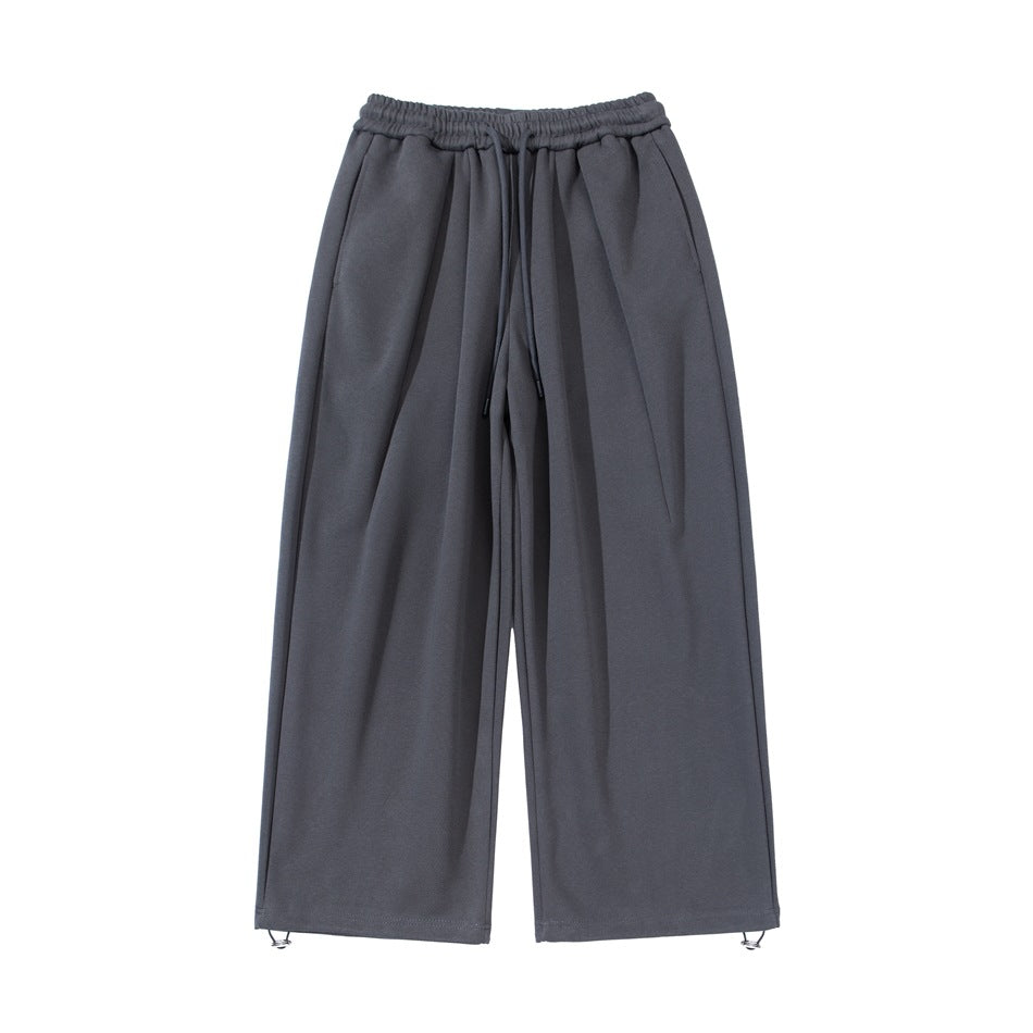 Dark gray wide-leg drawstring sweatpants, flat front view with elastic waistband and toggle hems