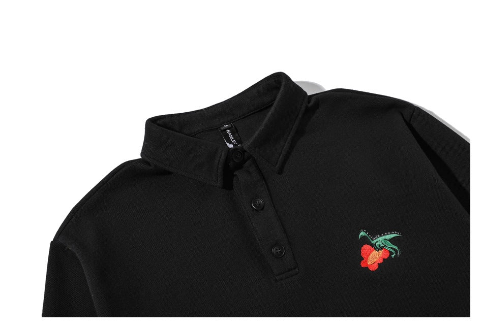Close-up of a black polo-style collar and three-button placket with a small red-and-green embroidered motif.