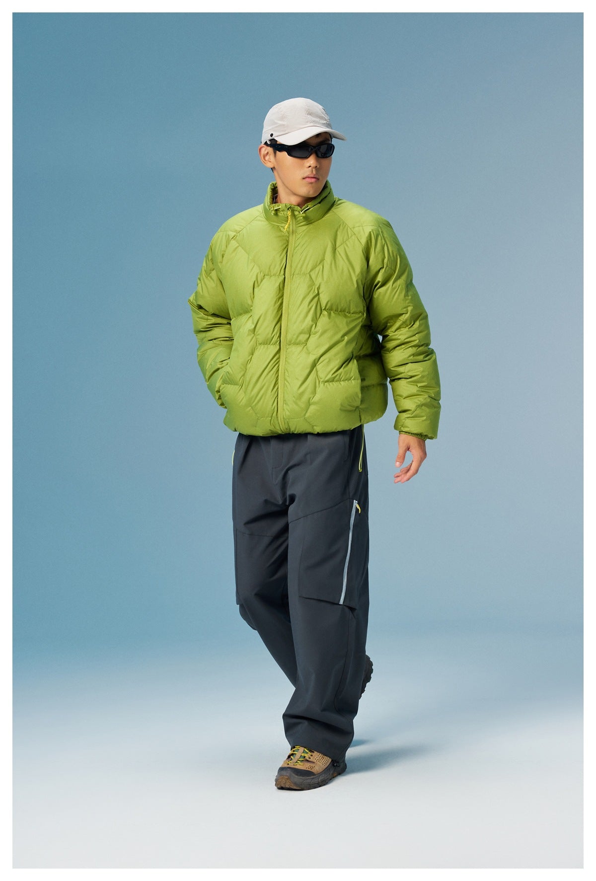 Model wearing a lime-green quilted zip jacket with a high collar and dark cargo pants, shown full length from the front.
