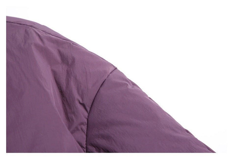 Close-up of a plum-purple garment showing a curved shoulder seam and stitched panel.