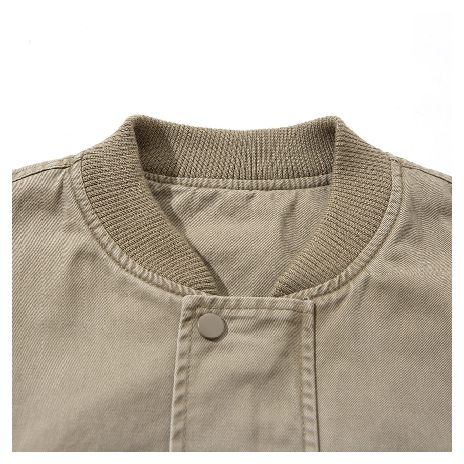 Close-up of a light taupe jacket's ribbed collar and snap-fastening front placket.