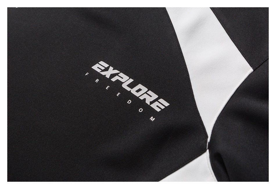 Close-up of white “EXPLORE FREEDOM” lettering on the black shirt beside a white panel.