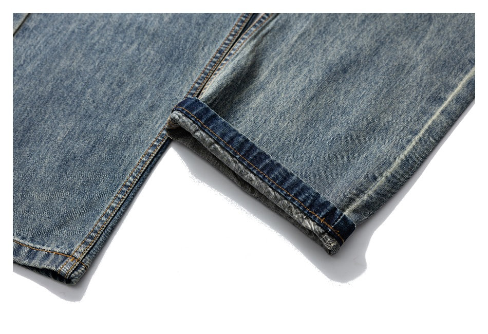 Close-up of a folded blue denim jean hem, showing the inner fabric and contrast stitching.