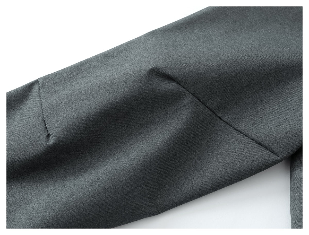 Close-up of dark gray garment fabric with a curved seam and visible folds.