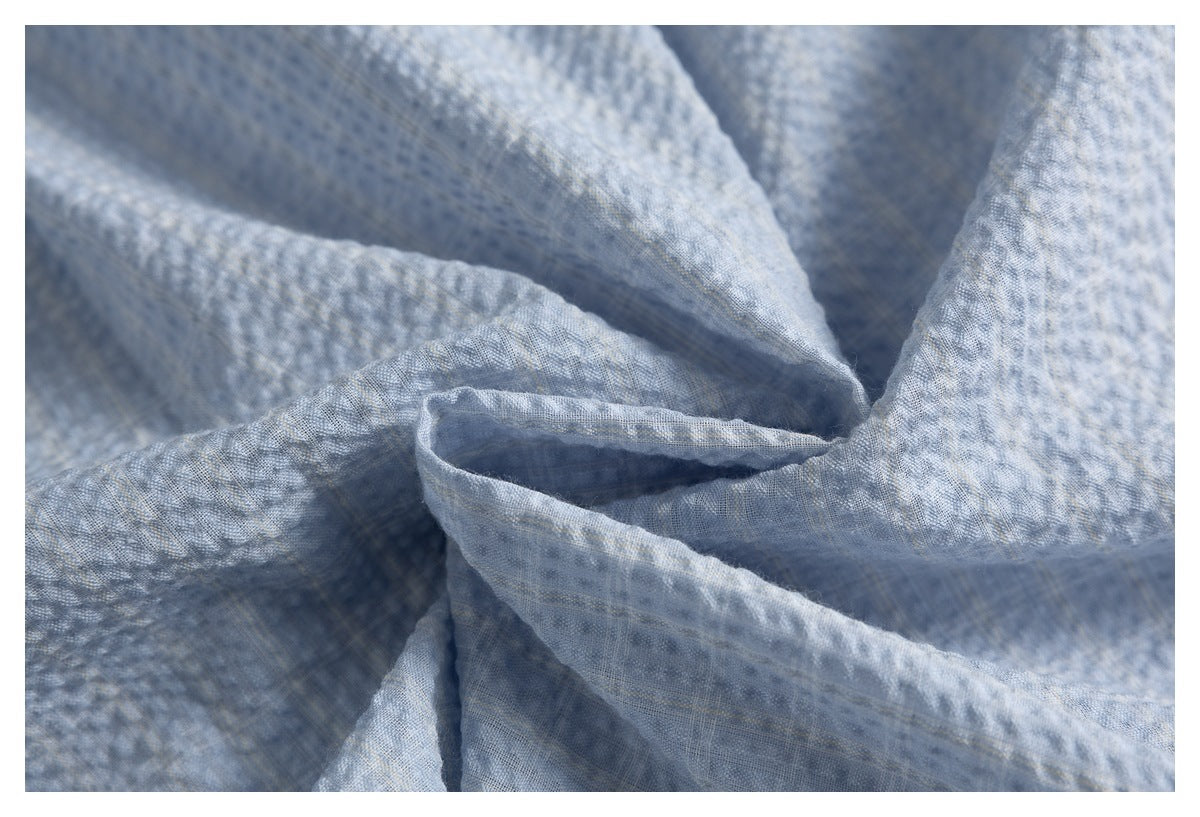 Close-up showing the soft folds and textured surface of light blue-gray fabric.