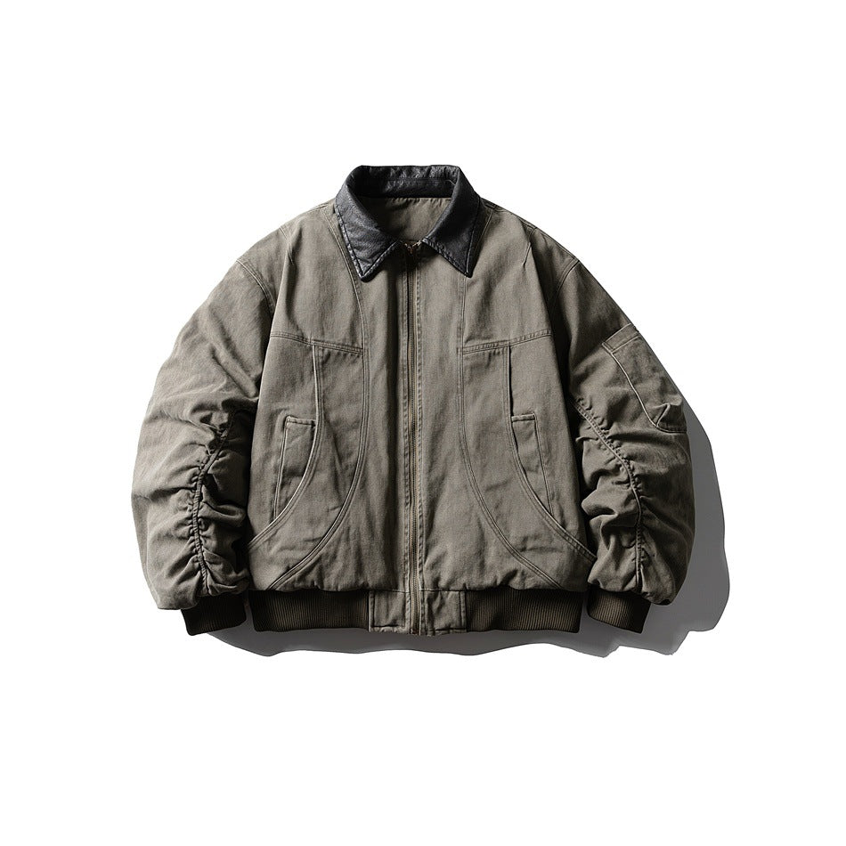 Green padded bomber jacket with dark leather-look collar, front zipper, curved seams and ruched sleeves, flat lay