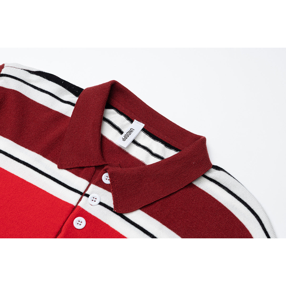 Close-up of a burgundy polo collar and white buttons on a red, white and black striped shirt.