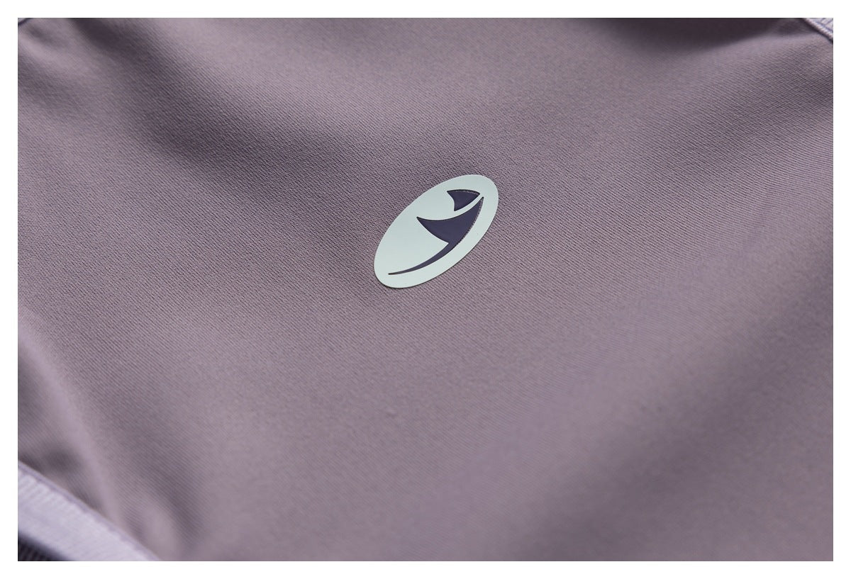 Close-up of mauve fabric with a small pale emblem.