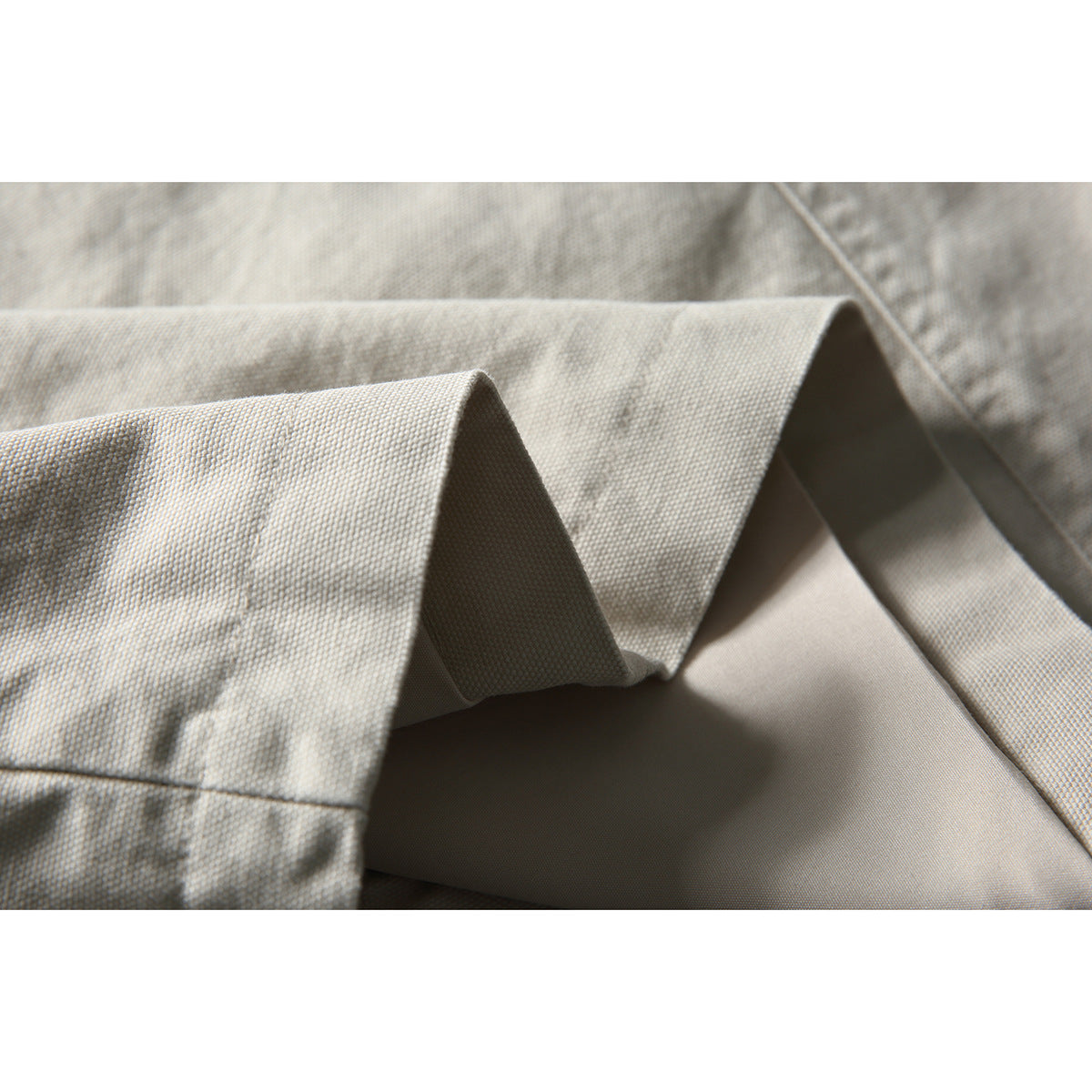 Close-up of the off-white jacket's folded collar edge and inner lining.
