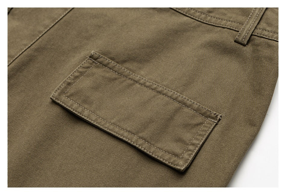 Close-up of an olive-brown trouser leg with a rectangular stitched patch pocket and belt loop.