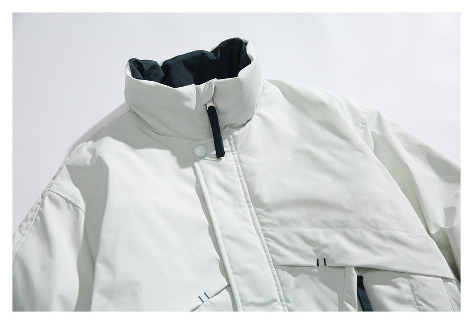 Close view of a white jacket front showing its high collar, black zipper pull, and snap-fastened storm flap.
