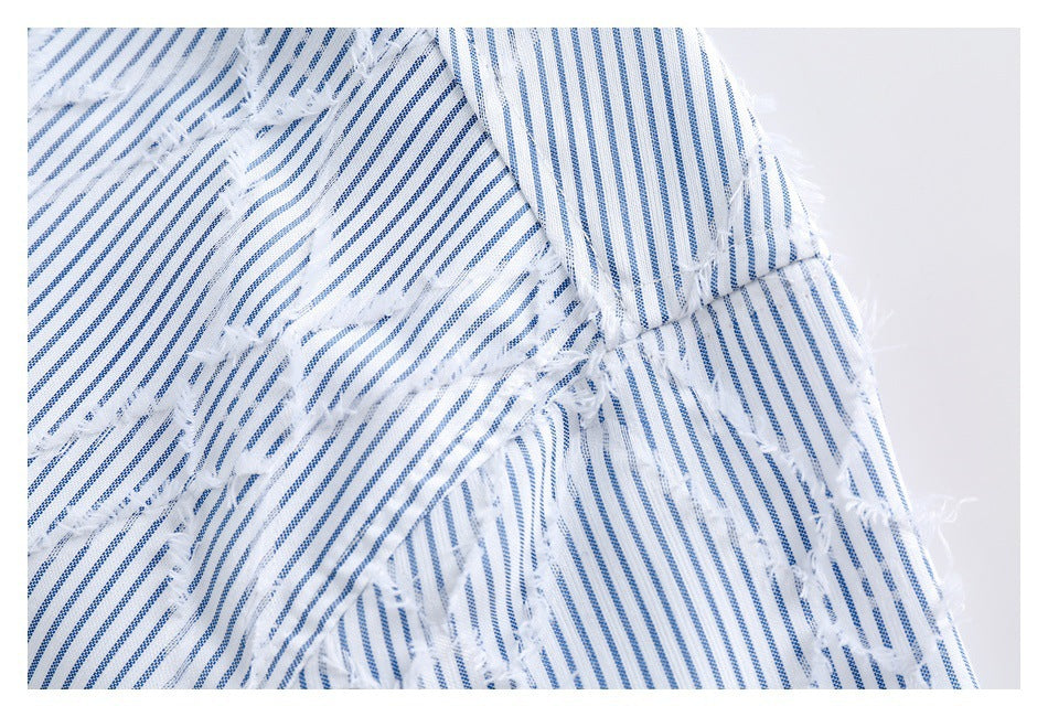 Close-up of a seam and overlapping panels on blue-and-white striped fabric with frayed edges.