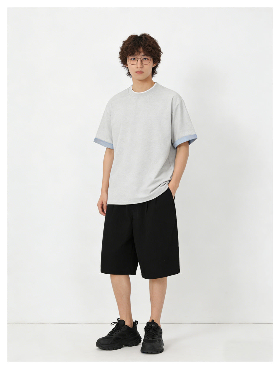 Model wearing a light gray short-sleeve crew-neck T-shirt with pale blue sleeve-cuff trim.