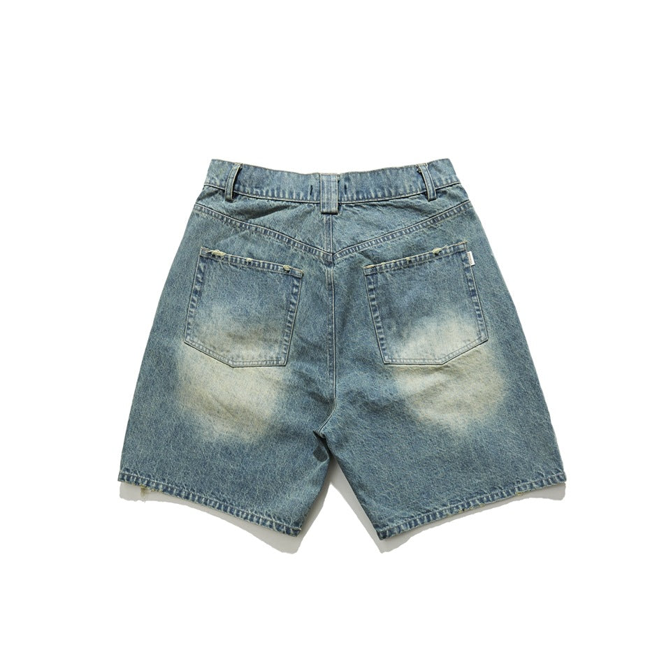 Back of vintage blue washed denim shorts with two patch pockets, faded seat and frayed hems