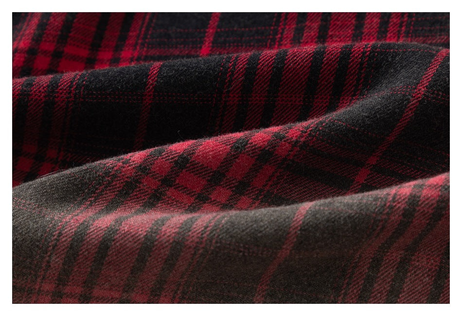 Extreme close-up of red and black plaid fabric arranged in soft folds.