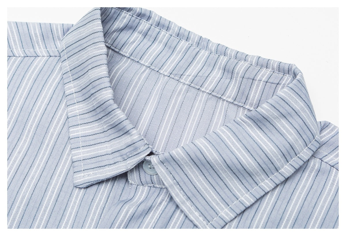 Close-up of a pale blue shirt collar with fine white and dark blue vertical stripes and a button.