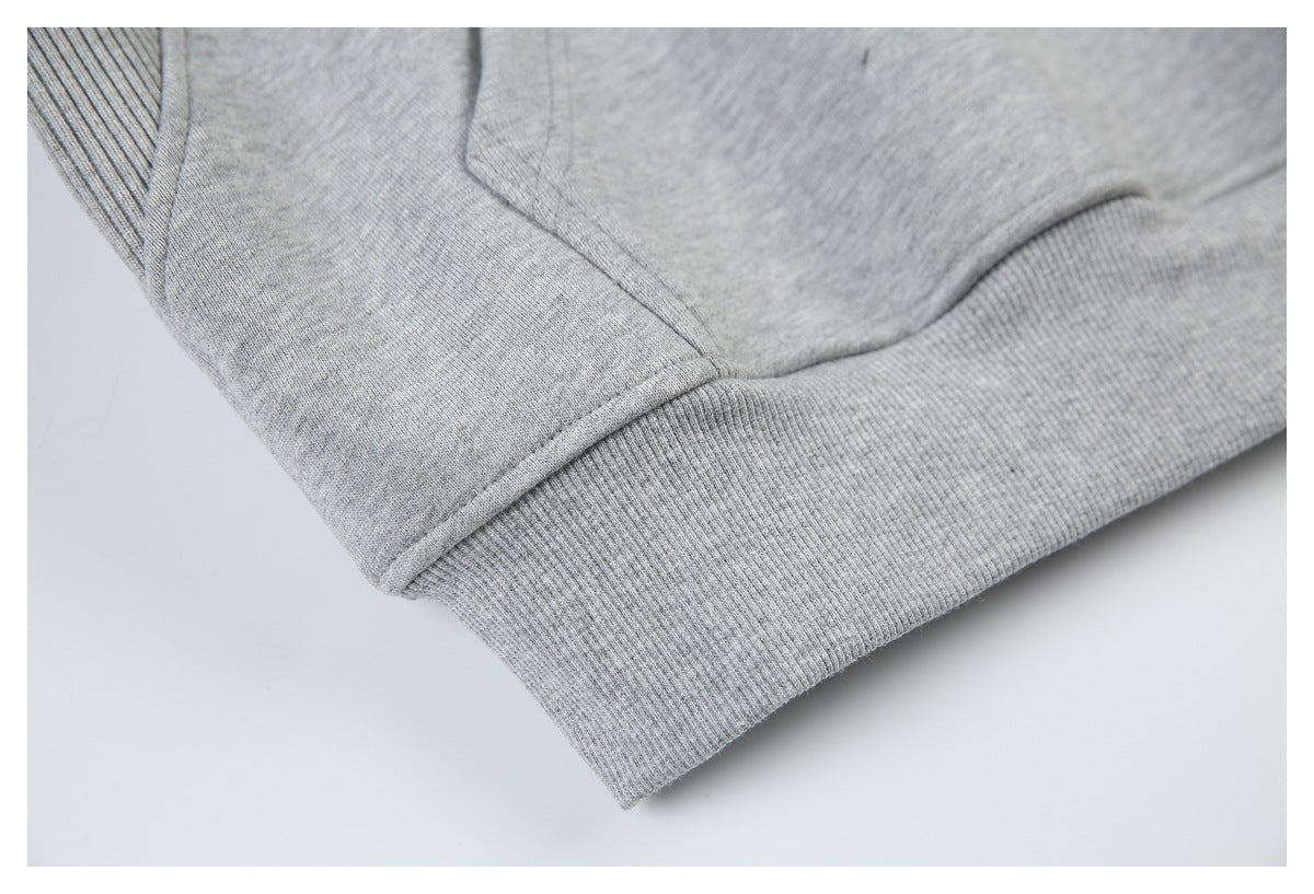 Close-up of a light gray sweatshirt hem with wide ribbed trim and stitching.