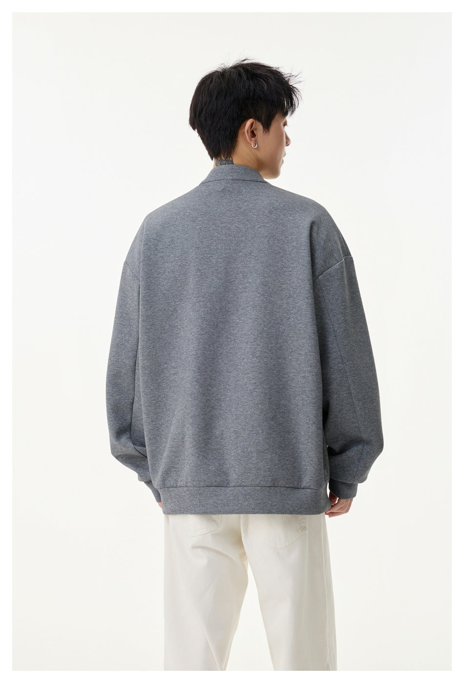 Back view of a model wearing a gray jacket with a ribbed hem and cuffs.