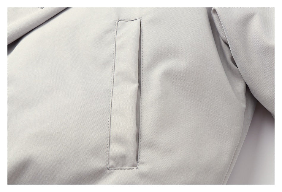 Close-up of a narrow vertical welt pocket on a light gray jacket.