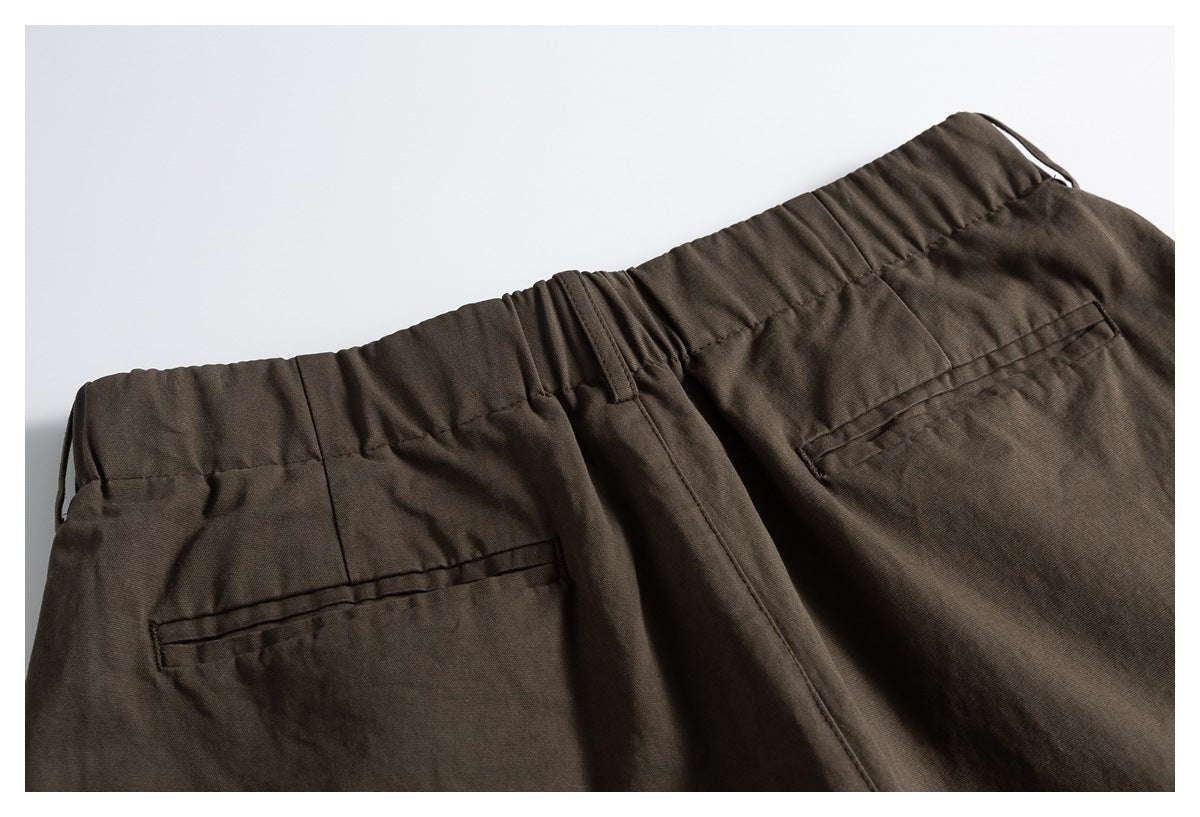 Back waistband of dark brown trousers with belt loops and two welt pockets.