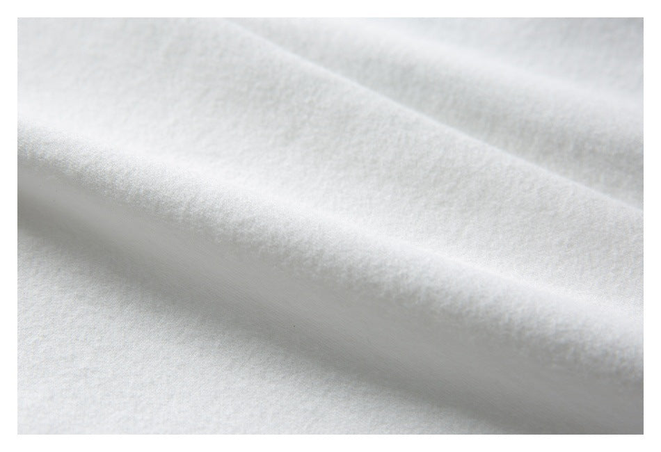 Extreme close-up of the soft-looking, textured surface of white garment fabric.