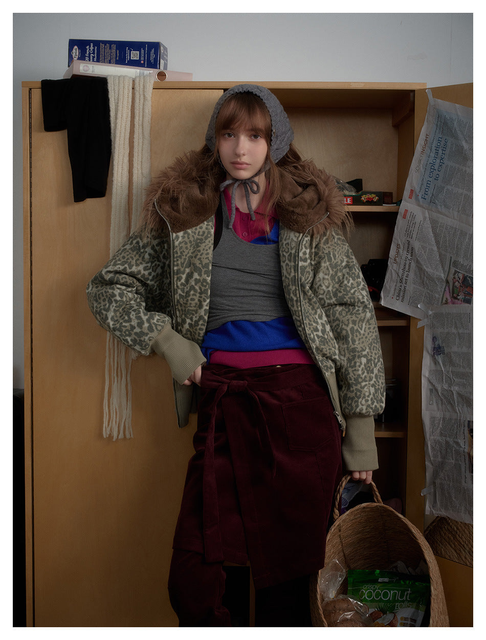 Model wearing an open gray leopard-print jacket with brown fur trim over layered tops and burgundy clothing.