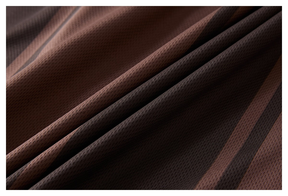 Close-up of brown and dark striped mesh fabric draped in folds.