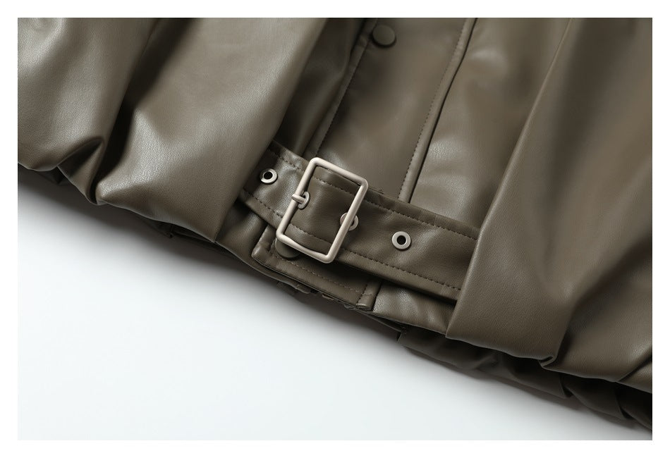 Close-up of an olive-brown jacket's waist belt and rectangular buckle, with snap buttons nearby.