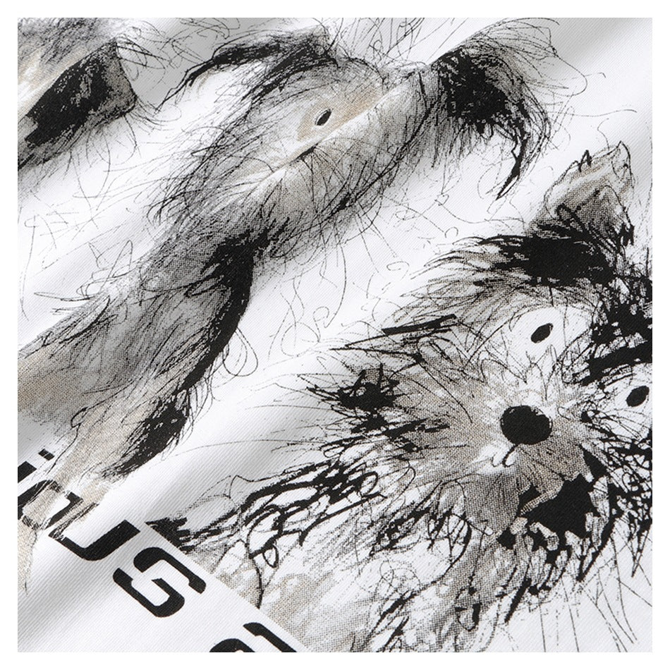 Close-up of a black-and-gray abstract fish and brushstroke graphic with partial black lettering on white fabric.