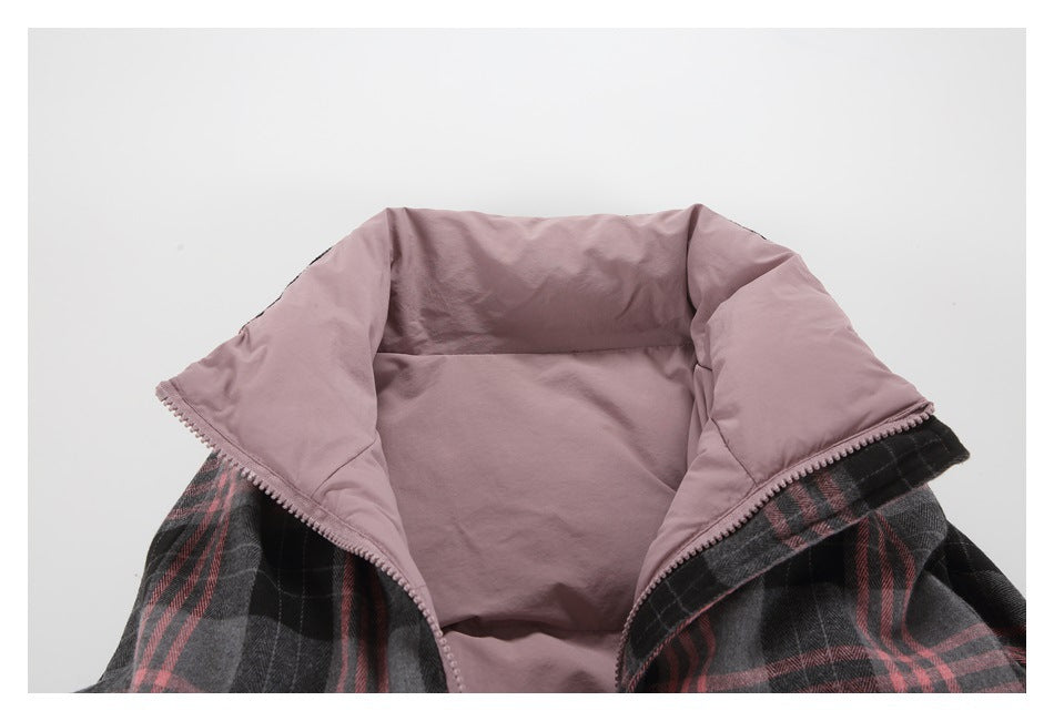 Inside of a jacket showing dusty mauve lining, a zippered edge, and charcoal plaid exterior with pink stripes.