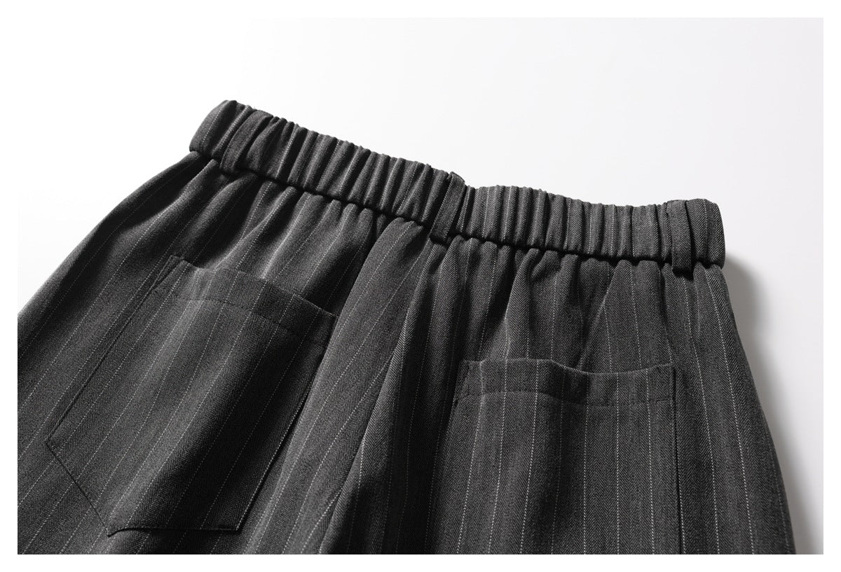 Upper back view of charcoal pinstripe trousers with an elasticated waistband and two patch pockets.