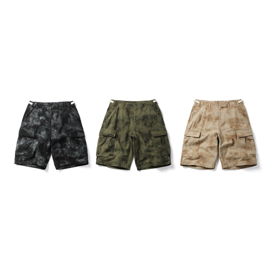 Three pairs of cargo shorts shown from the front in black, olive green, and tan mottled colorways.