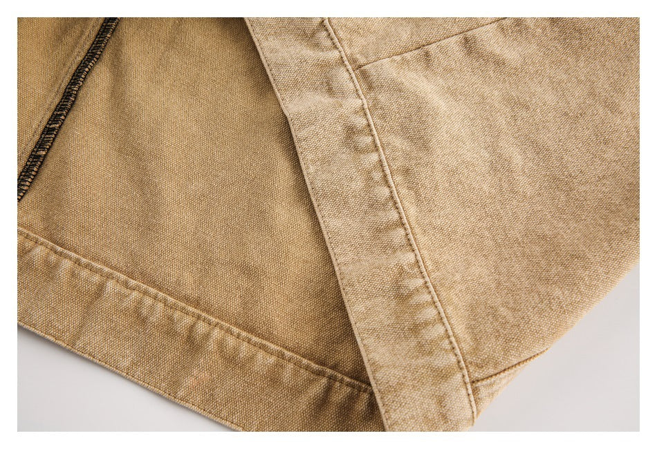 Close-up of tan garment fabric showing an inner seam, folded edge and contrasting dark stitching.