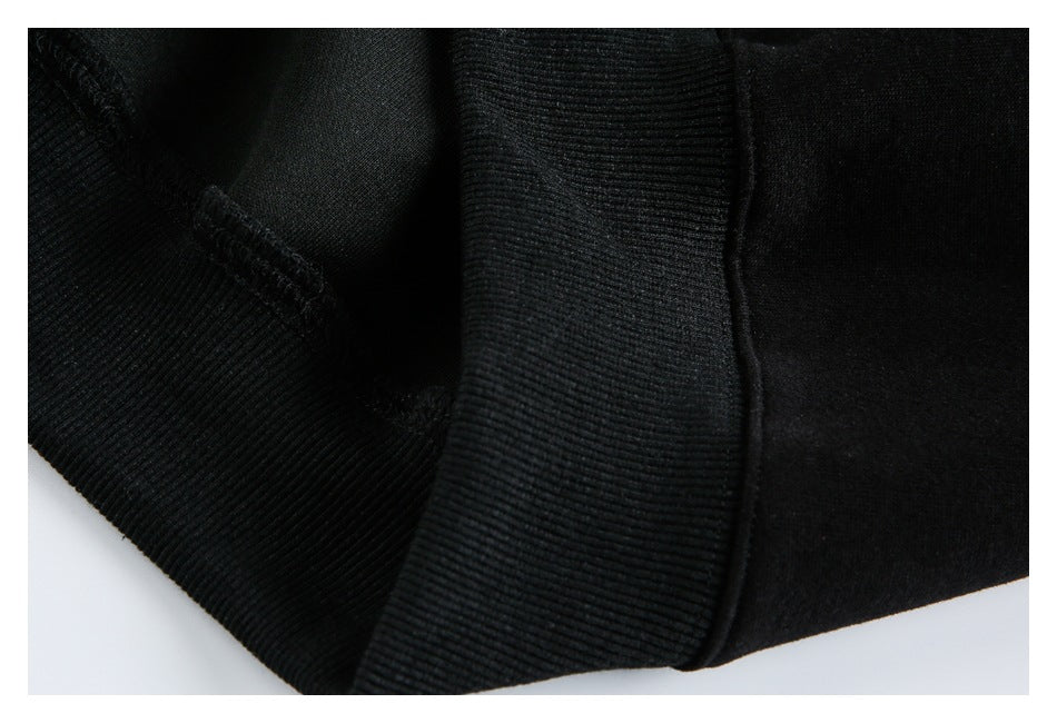 Close-up of a black garment's ribbed hem and stitched seam.