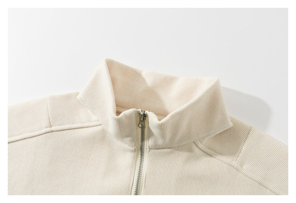 Close-up of an ivory ribbed top with a wide collar and silver front zipper.