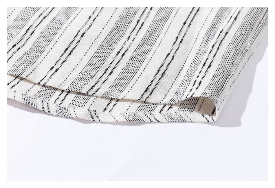 Close-up of the cream shirt's hem and black stripe pattern.