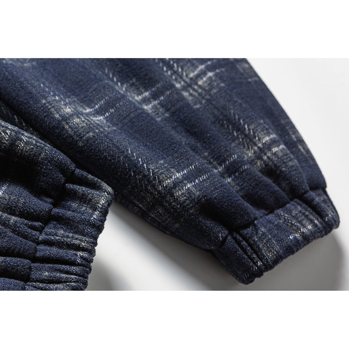 Close-up of the dark navy plaid jacket's sleeve and gathered elastic cuff.