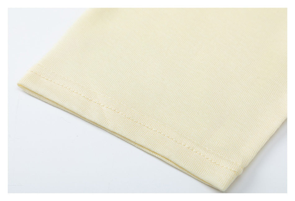 Close-up of a pale yellow garment's double-stitched hem.