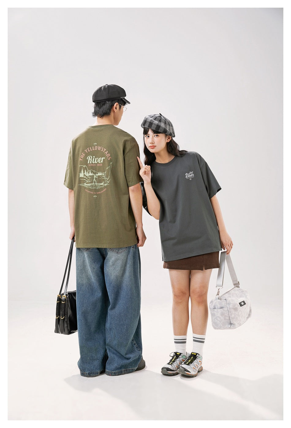 Two models show the olive T-shirt's illustrated back print and the charcoal T-shirt's small chest print.