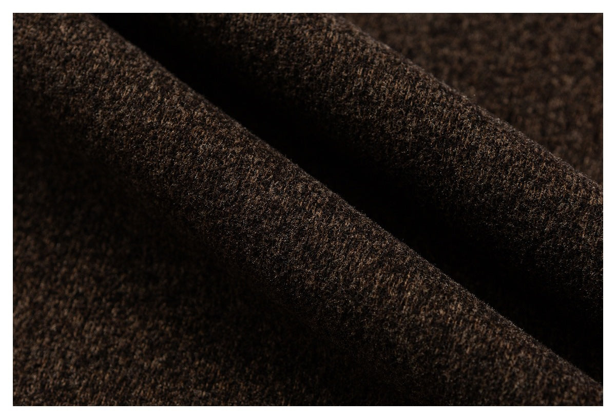 Close-up of dark brown fabric folded into soft ridges, showing a dense textured surface.