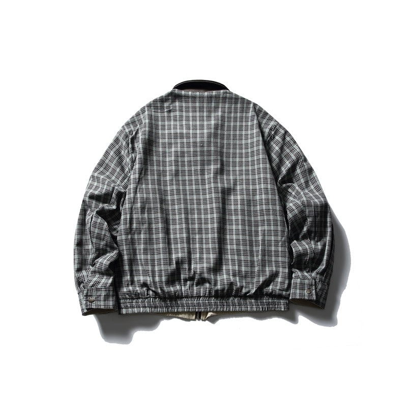 Back view of a gray and black plaid jacket with long sleeves, buttoned cuffs, and an elasticized hem.