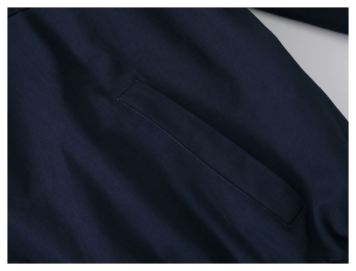 Close-up of a slanted welt pocket on dark navy jacket fabric.