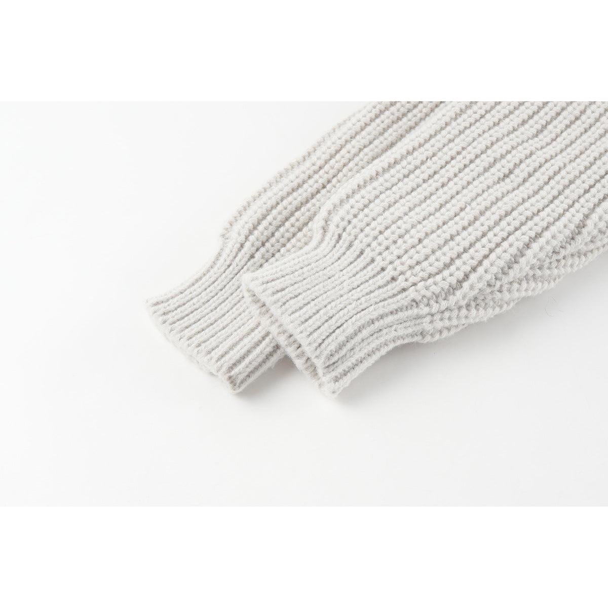 Close-up of the off-white cardigan's rib-knit sleeves and ribbed cuffs.