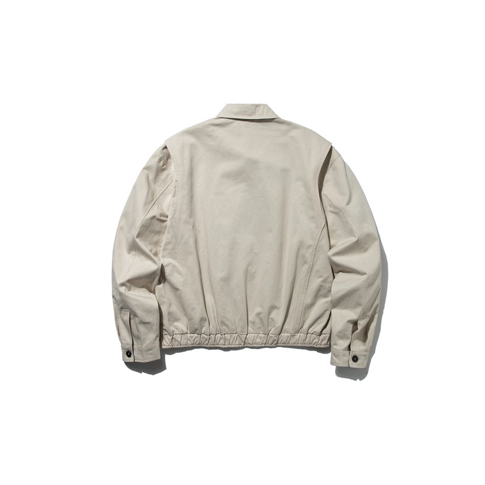 Back view of a light beige jacket with a pointed collar, gathered hem, and buttoned cuffs.