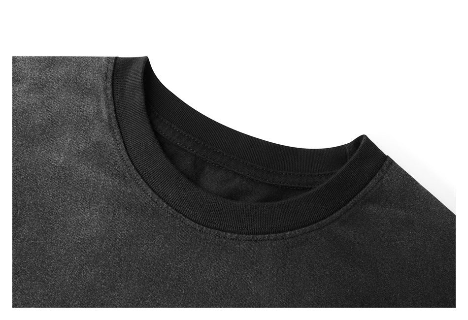 Close-up of a charcoal-black T-shirt showing its black ribbed crew neckline and shoulder fabric.